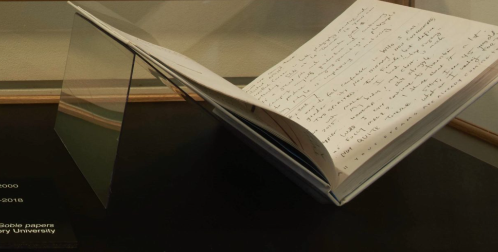 Book propped open in "Our Archives Could Be Your Life" display case