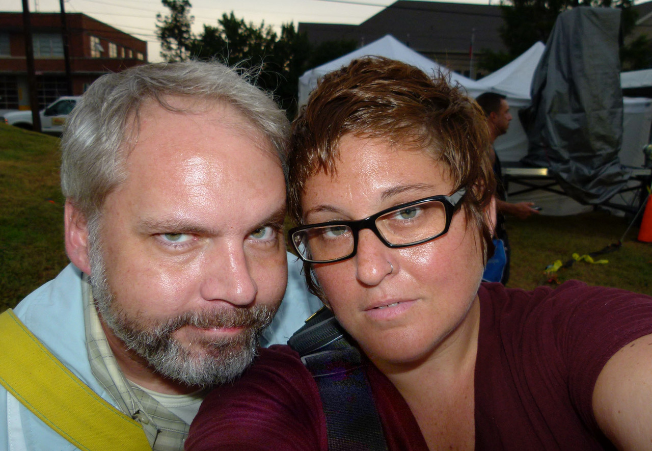 Selfie of Jon Arge, a man with light skin tone and gray hair, and Alli Royce Soble, a person with light skin tone, short brown hair, and black glasses