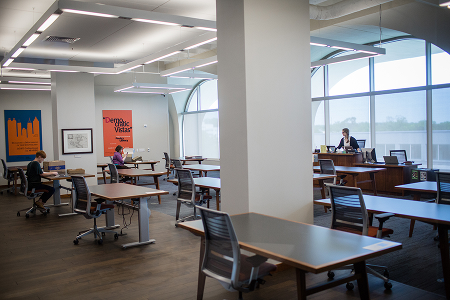 Brightly lit reading room with several rows of desks and chairs