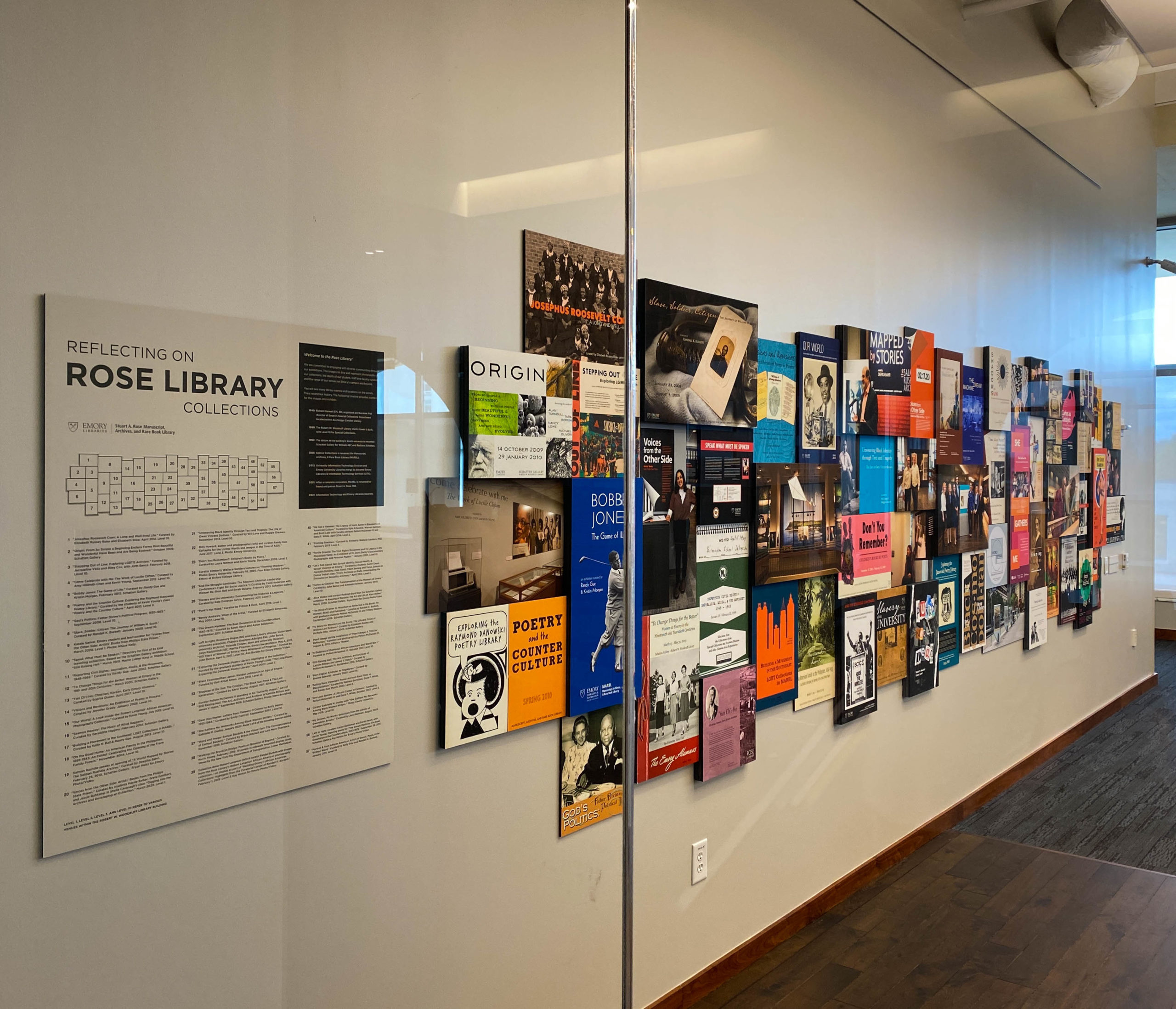 Collage of exhibit posters on white wall of Rose Library's reading room